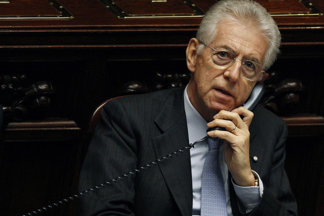 \'Italy\'s Prime Minister Mario Monti talks on the phone during a vote of confidence at the Lower House of Parliament in Rome, in this file photo taken November 18, 2011. With Italy fighting to emerge