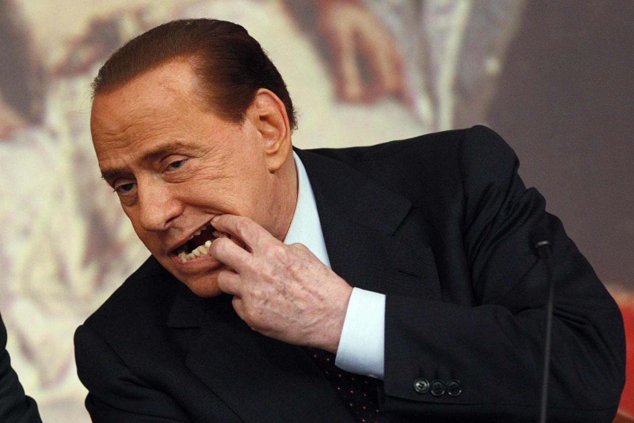 'Italy's Prime Minister Silvio Berlusconi shows his teeth during a news conference at Chigi palace in Rome in this February 9, 2011 file photograph. Italy looks set for lengthy political uncertainty 