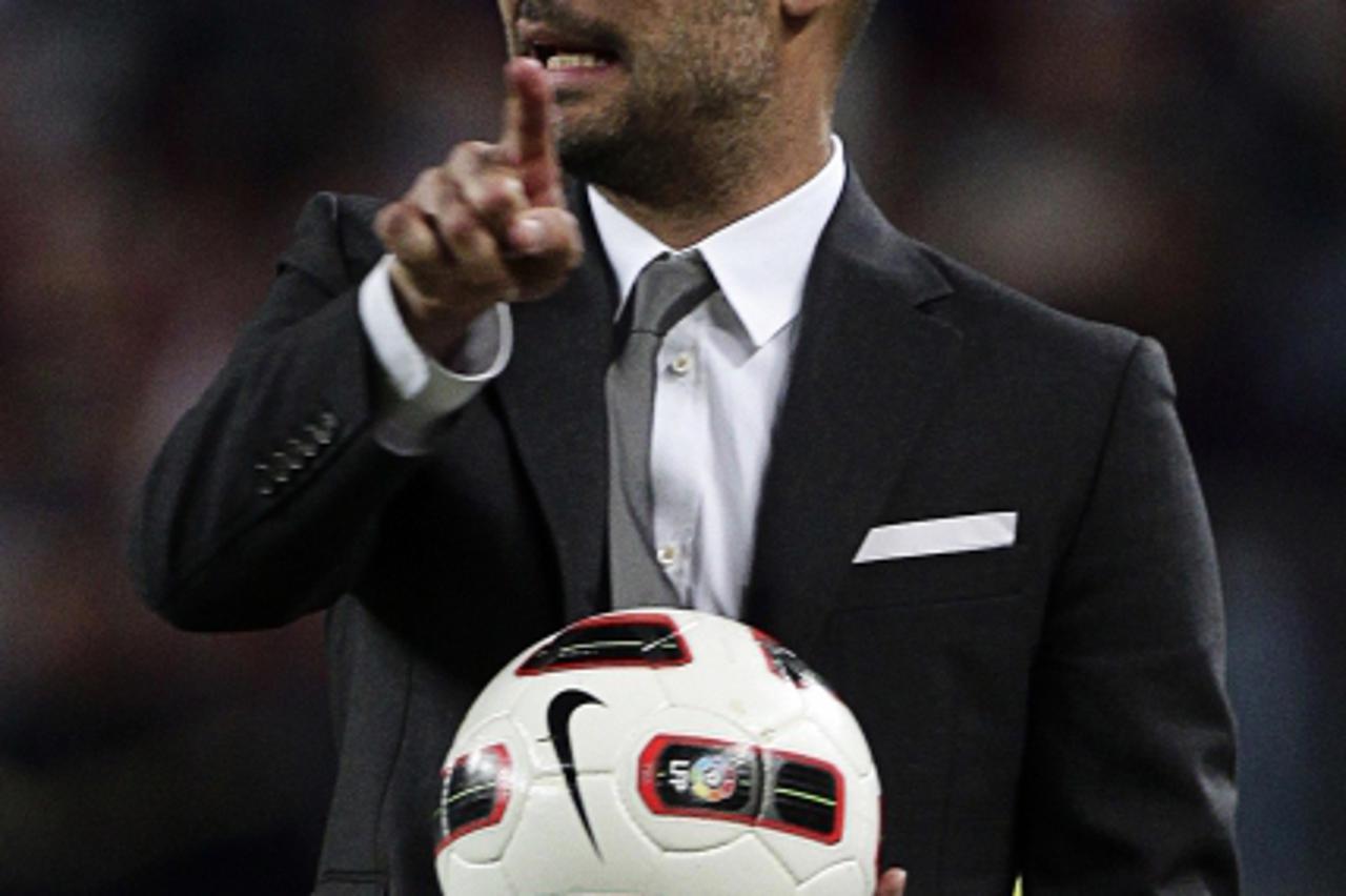 'Barcelona\'s coach Pep Guardiola gestures during their Spanish first division soccer match against Almeria at Camp Nou stadium in Barcelona April 9, 2011. REUTERS/ Albert Gea (SPAIN - Tags: SPORT SOC