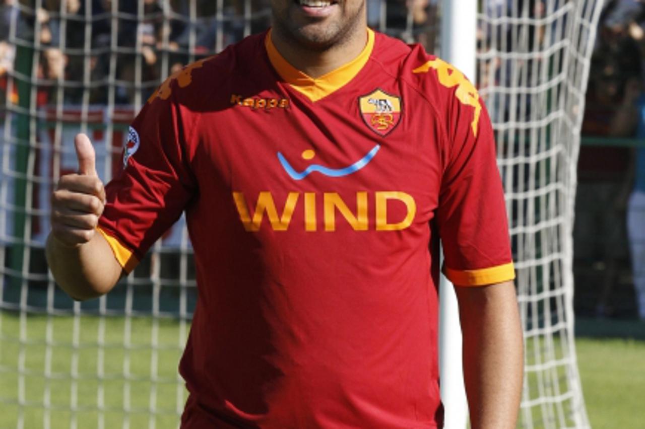\'AS Roma\'s newly signed member Adriano of Brazil poses with a team jersey at the end of a news conference for his presentation at the Flaminio stadium in Rome June 9, 2010. REUTERS/Giampiero Sposito