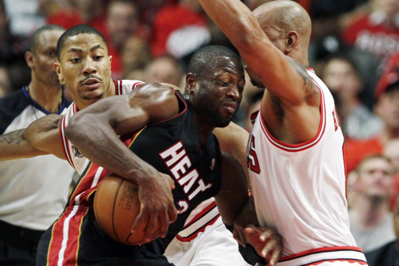 'Miami Heat\'s Dwyane Wade drives in between Chicago Bulls\' Derrick Rose (L) and Keith Bogans (R) during the second half in Game 1 of their NBA Eastern Conference Finals playoff basketball game in Ch