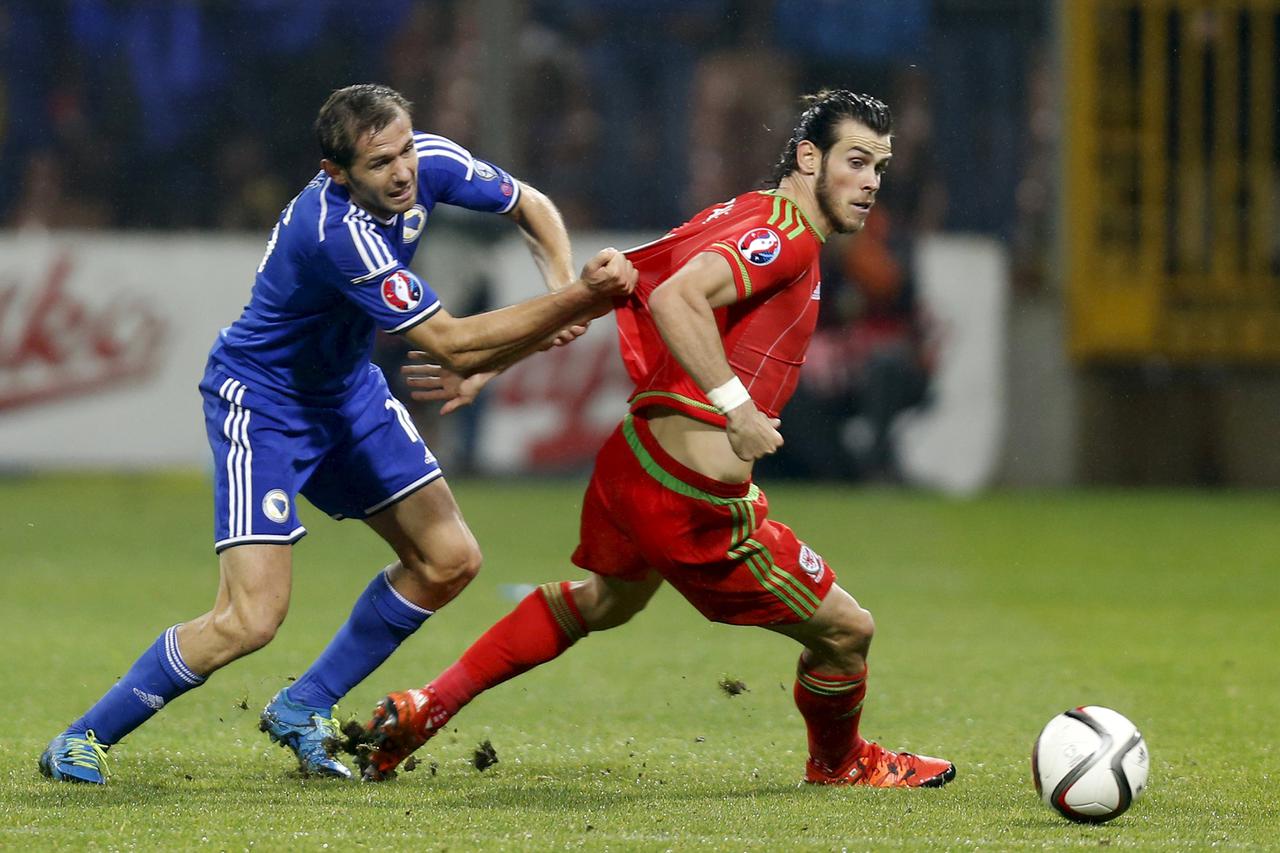 Bosnia's Senad Lulic (L) fights for the ball with Wales' Gareth Bale during their Euro 2016 qualifying soccer match in Zenica October 10, 2015. REUTERS/Dado Ruvic