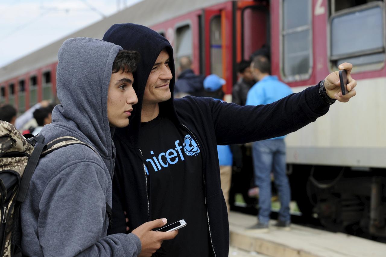 UNICEF Goodwill Ambassador Orlando Bloom (R) takes a selfie with Tariq Maria from Damascus, Syria as he visits the migrant transit camp in Gevgelija, Macedonia, where migrants are gathering after entering the country by crossing the border with Greece, Se