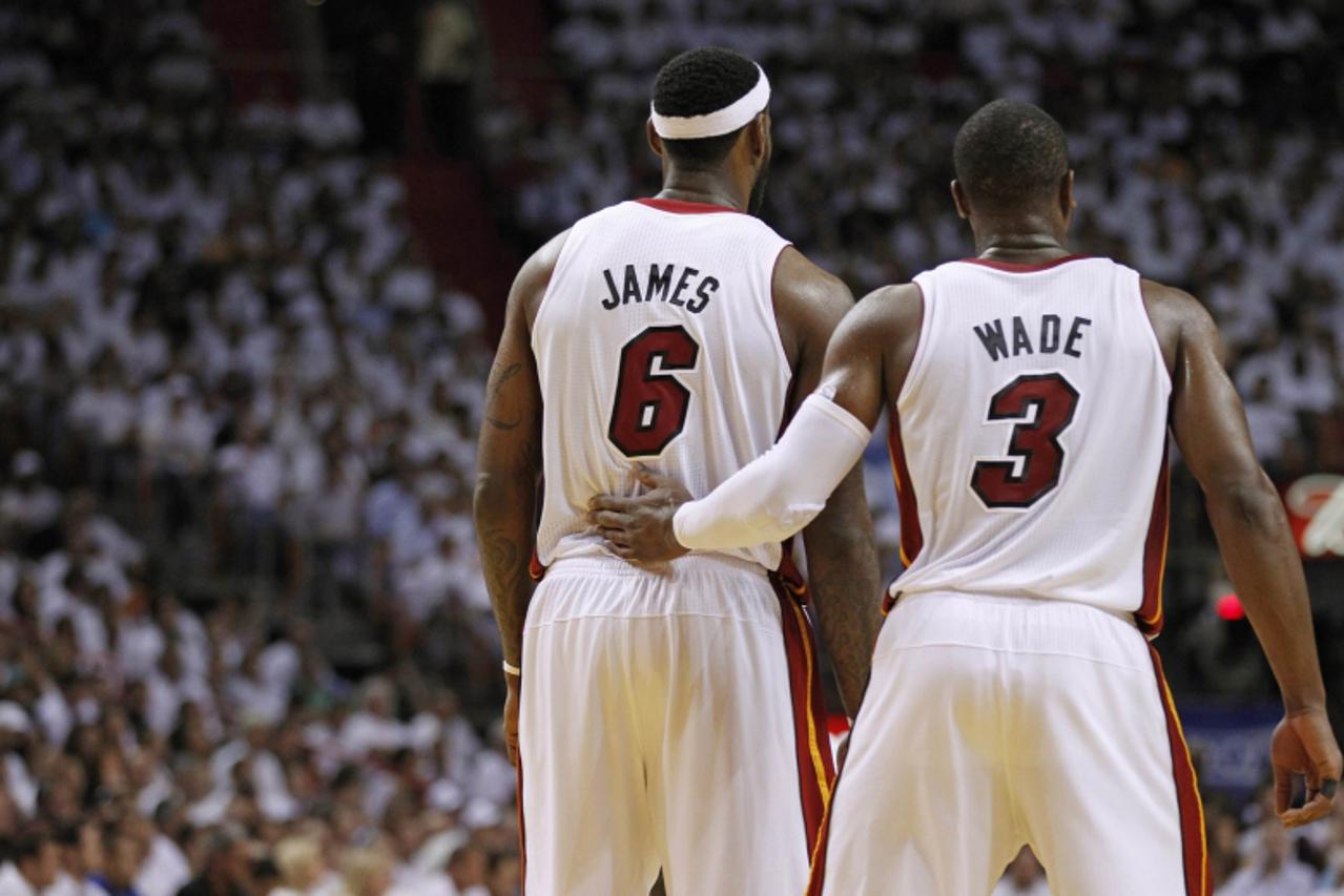'Miami Heat\'s LeBron James (L) and Dwyane Wade wait during a timeout against the Philadelphia 76ers during fourth quarter of Game 5 of their NBA Eastern Conference basketball playoff series in Miami 