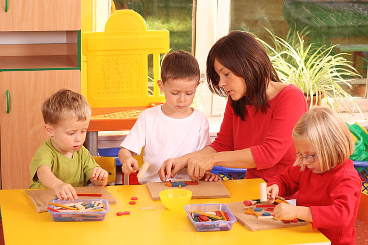 teacher and three preschoolers playing with wooden blocks