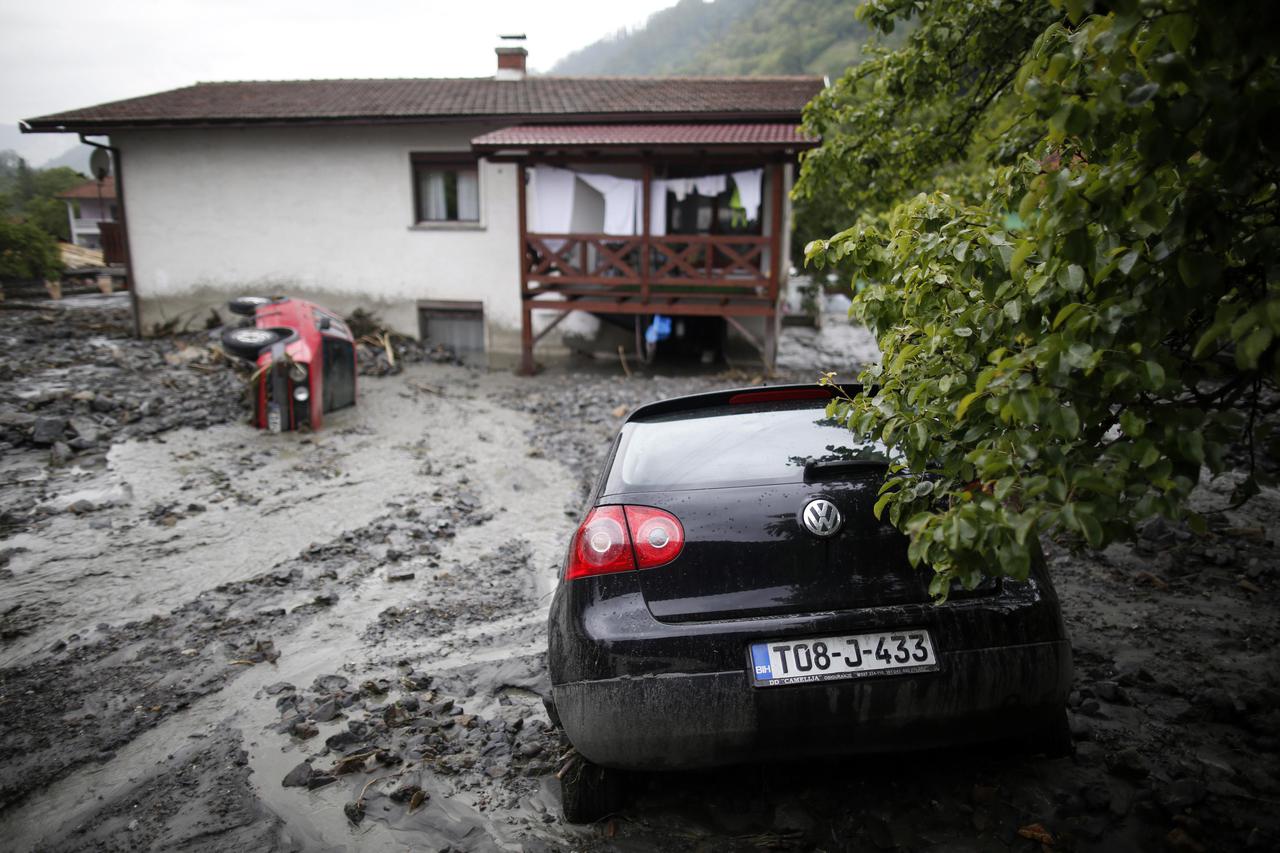 Cars stranded in mud are seen on a street that was hit by floods in Topcic Polje, near Zepce May 16, 2014. The heaviest rains and floods in 120 years have hit Bosnia and Serbia, killing five people, forcing hundreds out of their homes and cutting off enti