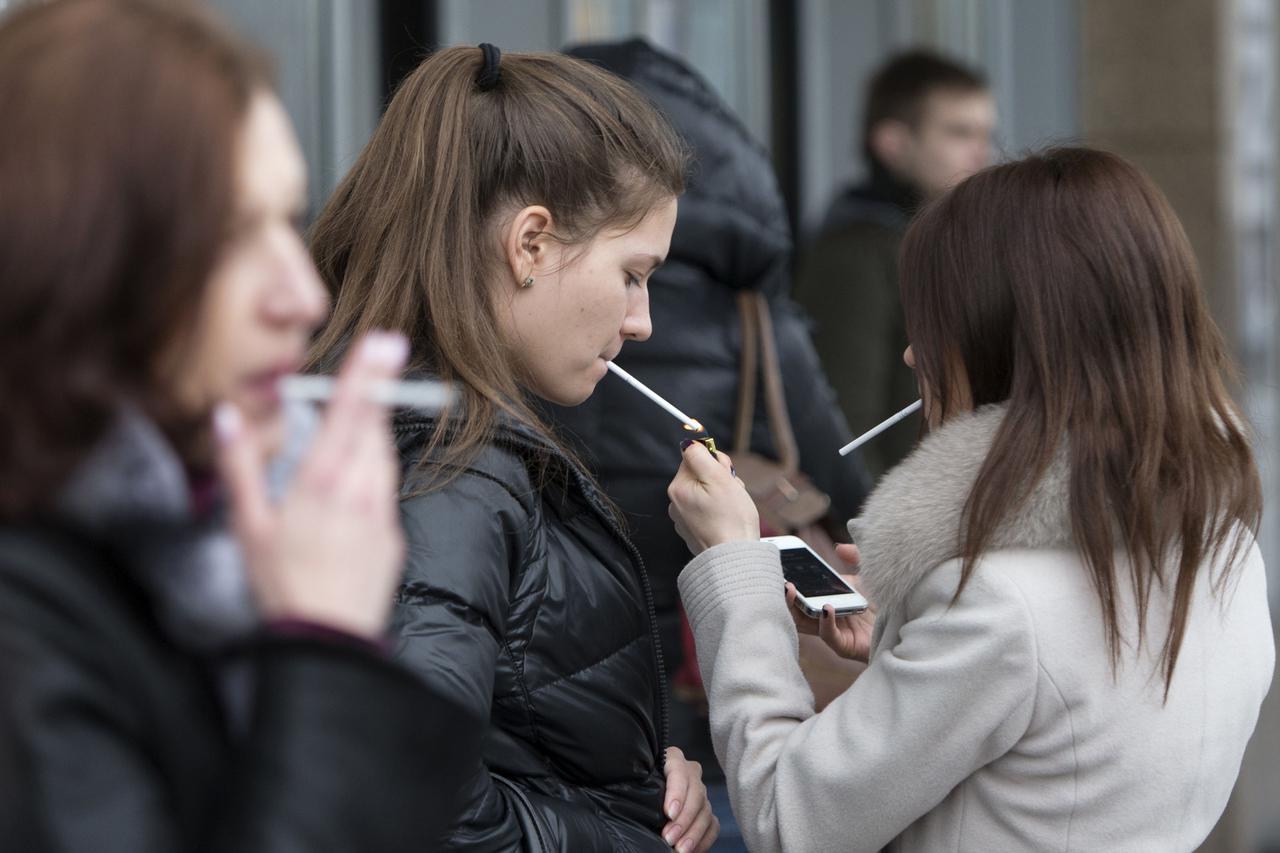Women smoke cigarettes at a shopping center in Moscow, Russia, Tuesday, Feb. 12, 2013. Russia's lower house of parliament has overwhelmingly passed a bill that would ban smoking in public places, a contentious measure in a country with one of the highest 