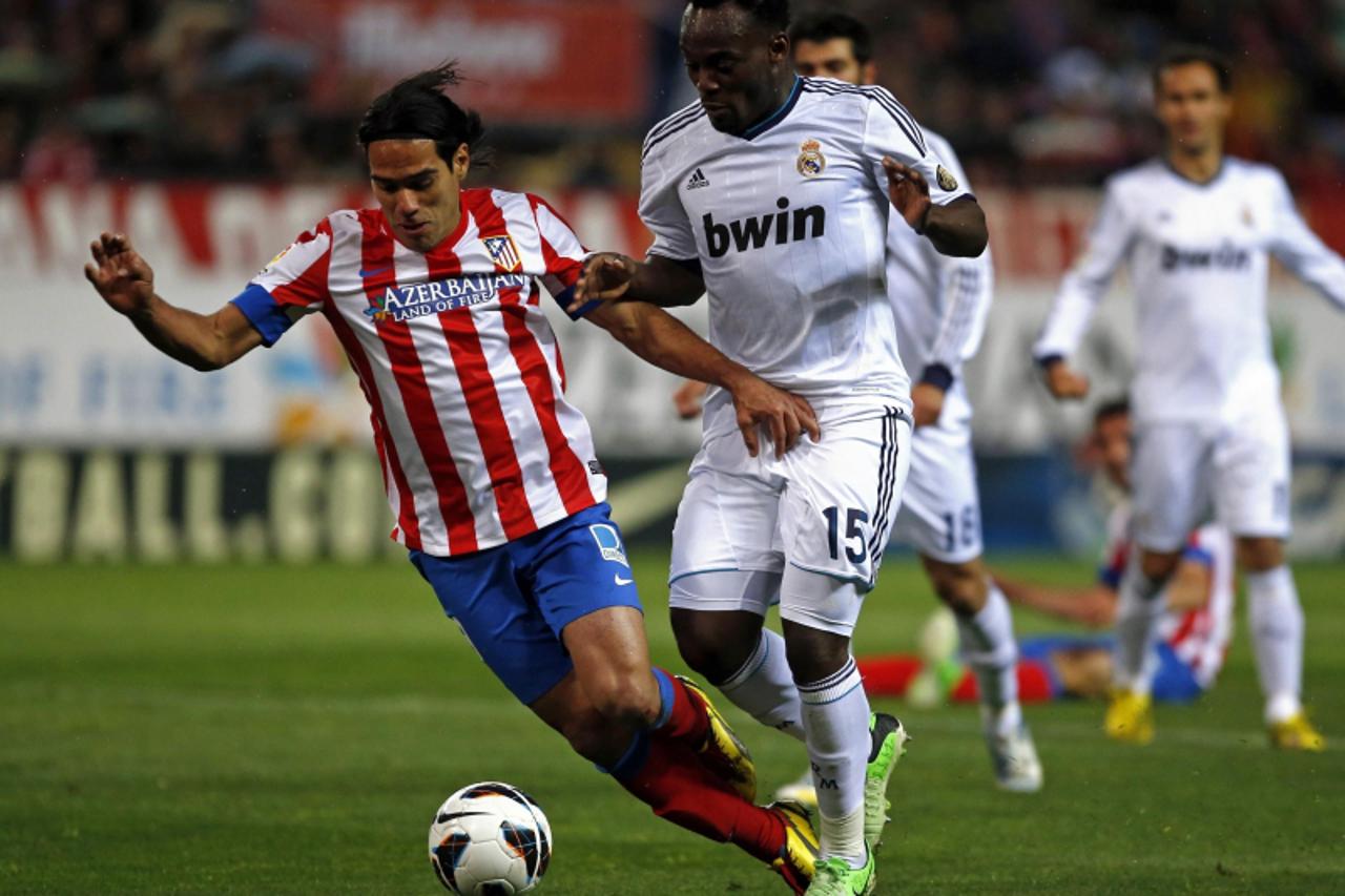 'Atletico Madrid\'s Radamel Falcao (L) is challenged by Real Madrid\'s Michael Essien during their Spanish first division soccer match at Vicente Calderon stadium in Madrid April 27, 2013.  REUTERS/Se