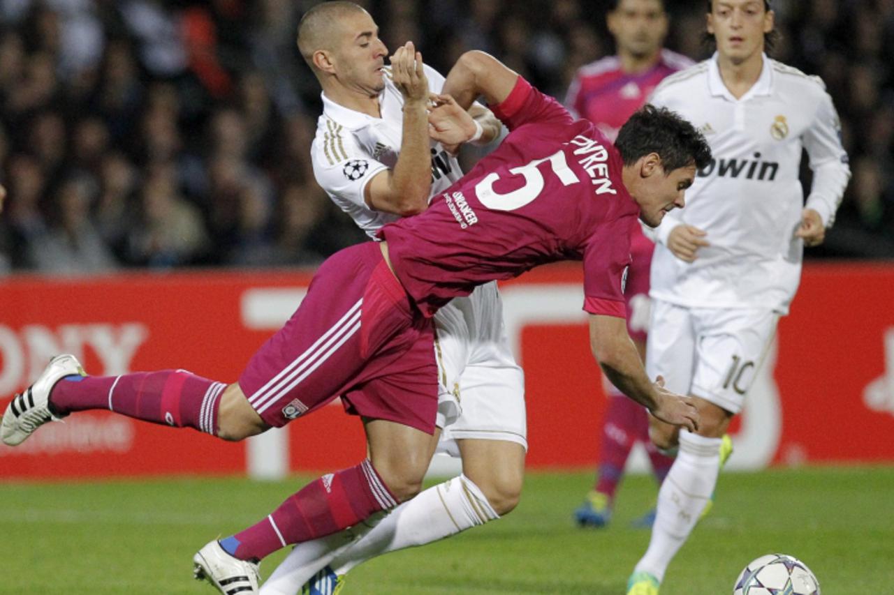 \'Olympique Lyon\'s Dejan Lovren (red) challenges Karim Benzema (L) of Real Madrid during their Champions League soccer match at the Gerland stadium in Lyon November 2, 2011.  REUTERS/Robert Pratta (F