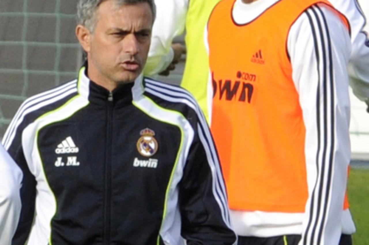 \'Real Madrid\'s Portuguese coach Jose Mourinho (L) and French forward Karim Benzema take part in a training session at Real Madrid\'s sport city on October 29, 2010 in Madrid.    AFP PHOTO/ DOMINIQUE