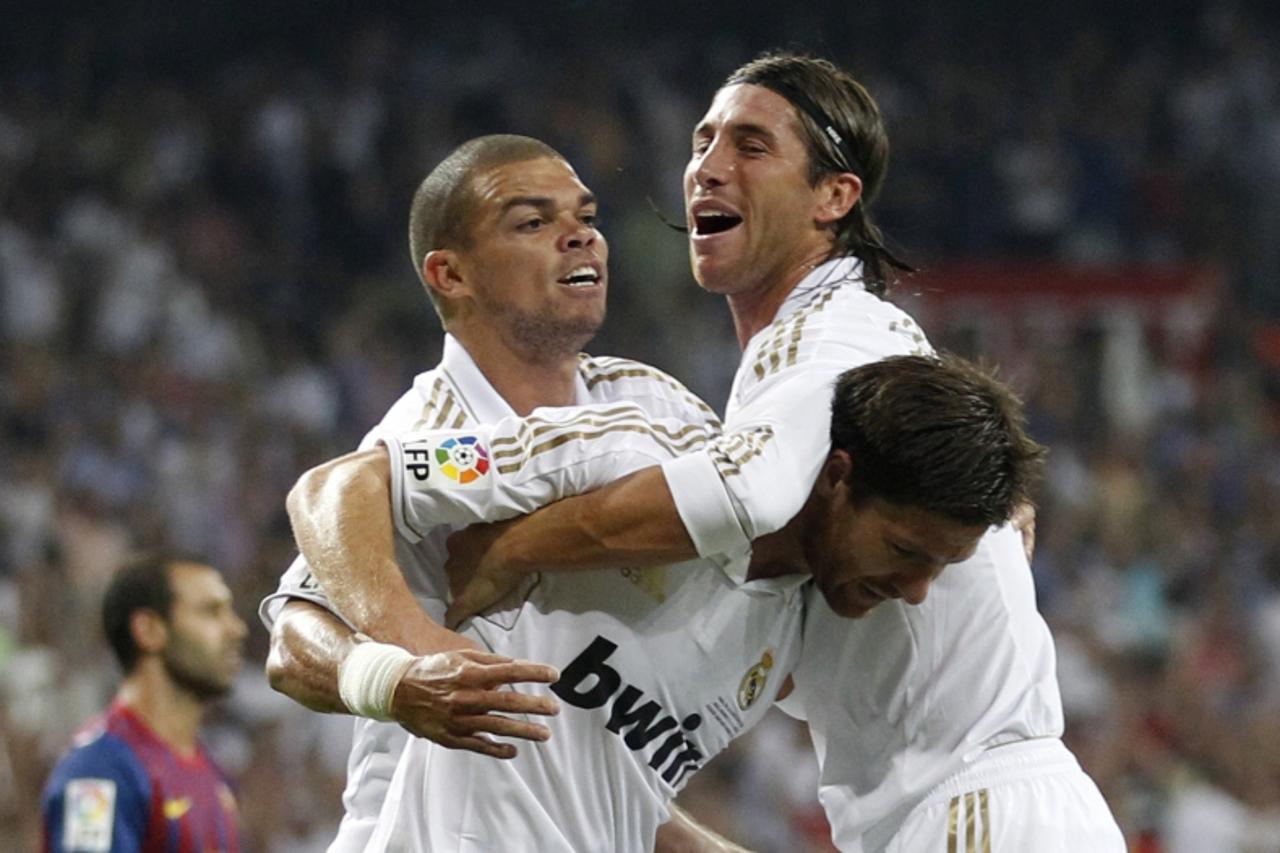 \'Real Madrid\'s Xabi Alonso is congratulated by his teammates Sergio Ramos (R) and Pepe (2nd L) for his goal against Barcelona during their Spanish Supercup first leg soccer match at the Santiago Ber