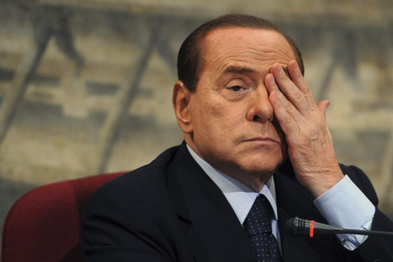 'Italian Prime Minister Silvio Berlusconi gestures during a presentation of a book by Italian member of Parliament Domenico Scilipoti at Montecitorio Palace in Rome July 7, 2011.  REUTERS/Stringer (IT