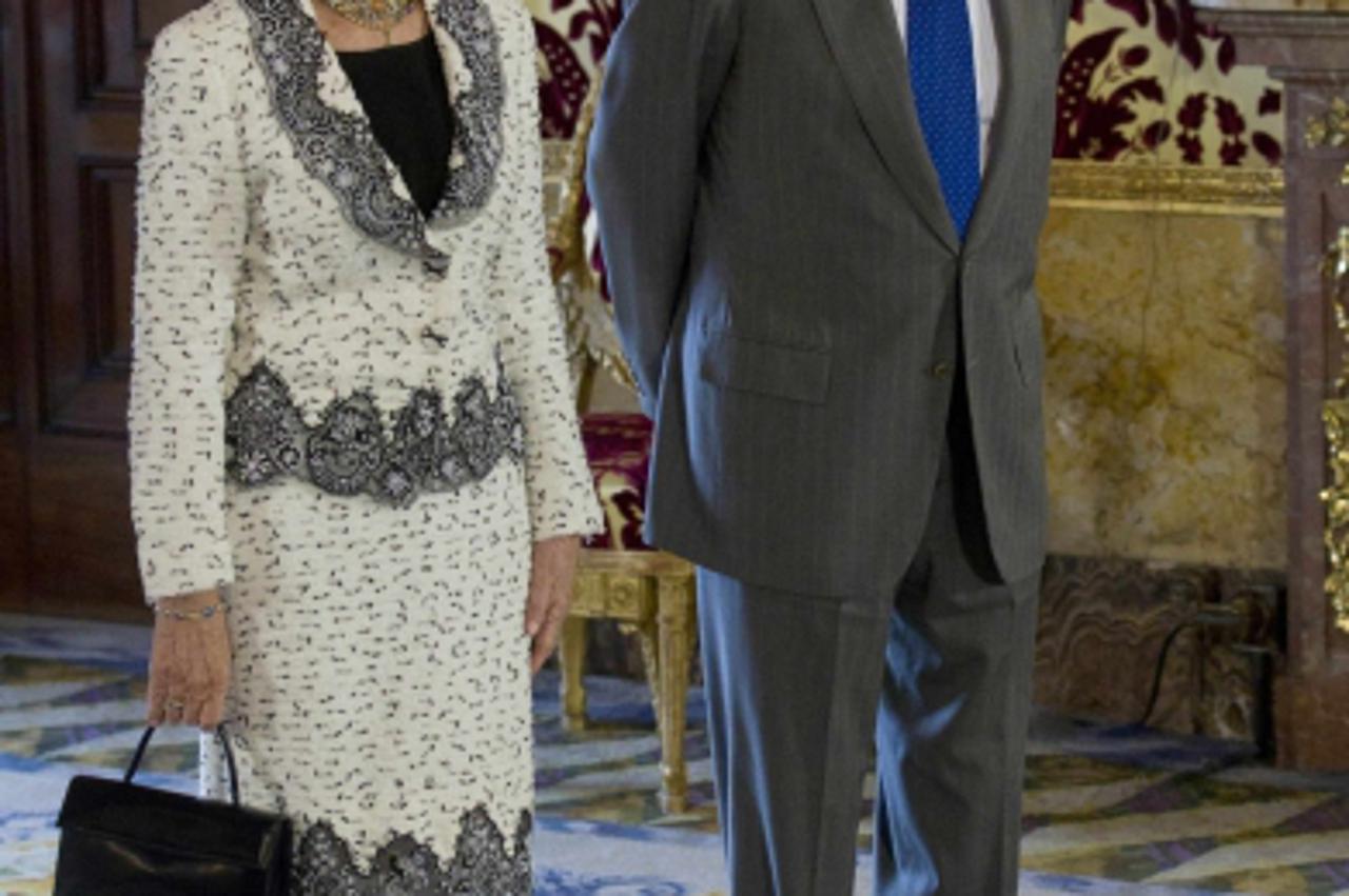 \'Spain\'s King Juan Carlos (R) and Queen Sofia stand before a lunch hosted by the royal family with the outgoing Spanish cabinet, at the Royal Palace in Madrid December 13, 2011. REUTERS/Paul White/P