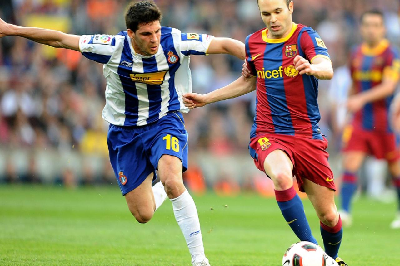 \'Espanyol\'s midfielder Javi Lopez (L) vies for the ball with Barcelona\'s midfielder Andres Iniesta (R) during the Spanish league football match between Barcelona and Espanyol at the Nou Camp stadiu