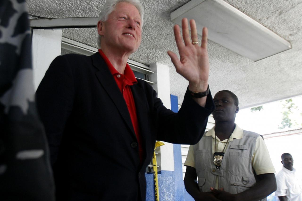 \'Former U.S. President and United Nations Special Envoy for Haiti Bill Clinton waves after meeting with Haiti\'s President Rene Preval in Port-au-Prince in this February 5, 2010 file photo. Clinton h