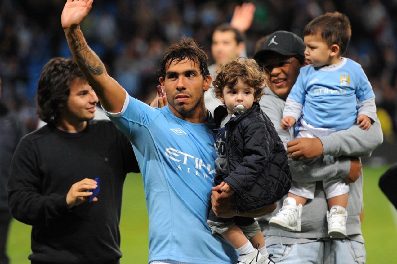 'Manchester City\'s Argentinian forward Carlos Tevez waves to fans during a lap of honour after the English Premier League football match between Manchester City and Stoke City at The City of Manchest