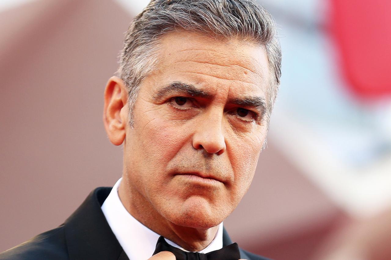 U.S. actor George Clooney adjusts his bowtie as he arrives for the premiere of 