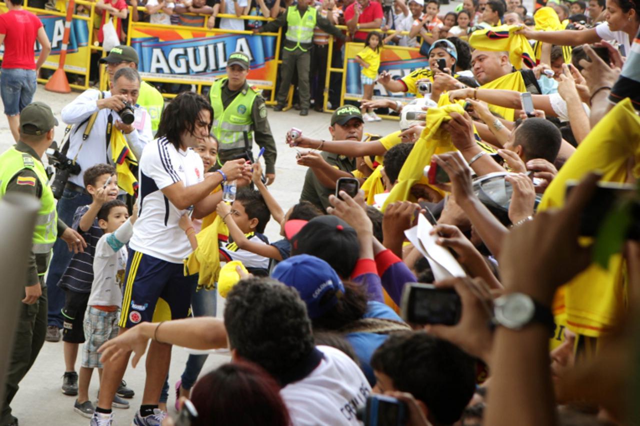 'Colombian player Radamel Falcao signs autographs to attend a soccer practice session in Barranquilla October 10, 2013. Colombia will face Chile in their 2014 World Cup qualifying soccer match on Frid