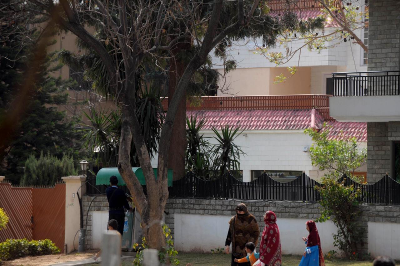 \'Pedestrians walk past a house where family members of slain Al-Qaeda leader Osama bin Laden are believed be be held, in Islamabad on March 17, 2012. A Pakistan court March 17 remanded family members