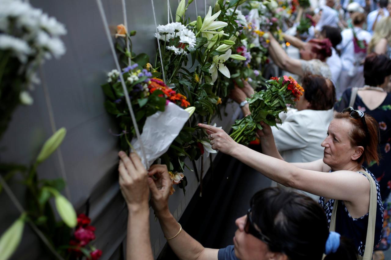 Women place flowers on a truck carrying coffins of newly identified victims of the 1995 Srebrenica massacre, in front of the presidential building in Sarajevo, Bosnia and Herzegovina, July 9, 2016. REUTERS/Dado Ruvic