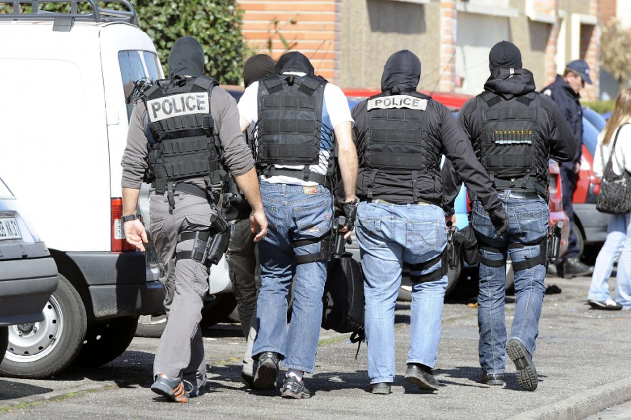 'Hooded policemen walk next to the building where self-professed Al-Qaeda militant Mohamed Merah, 23, was living on March 23, 2012  in Toulouse, southwestern France. French police today prolonged the 