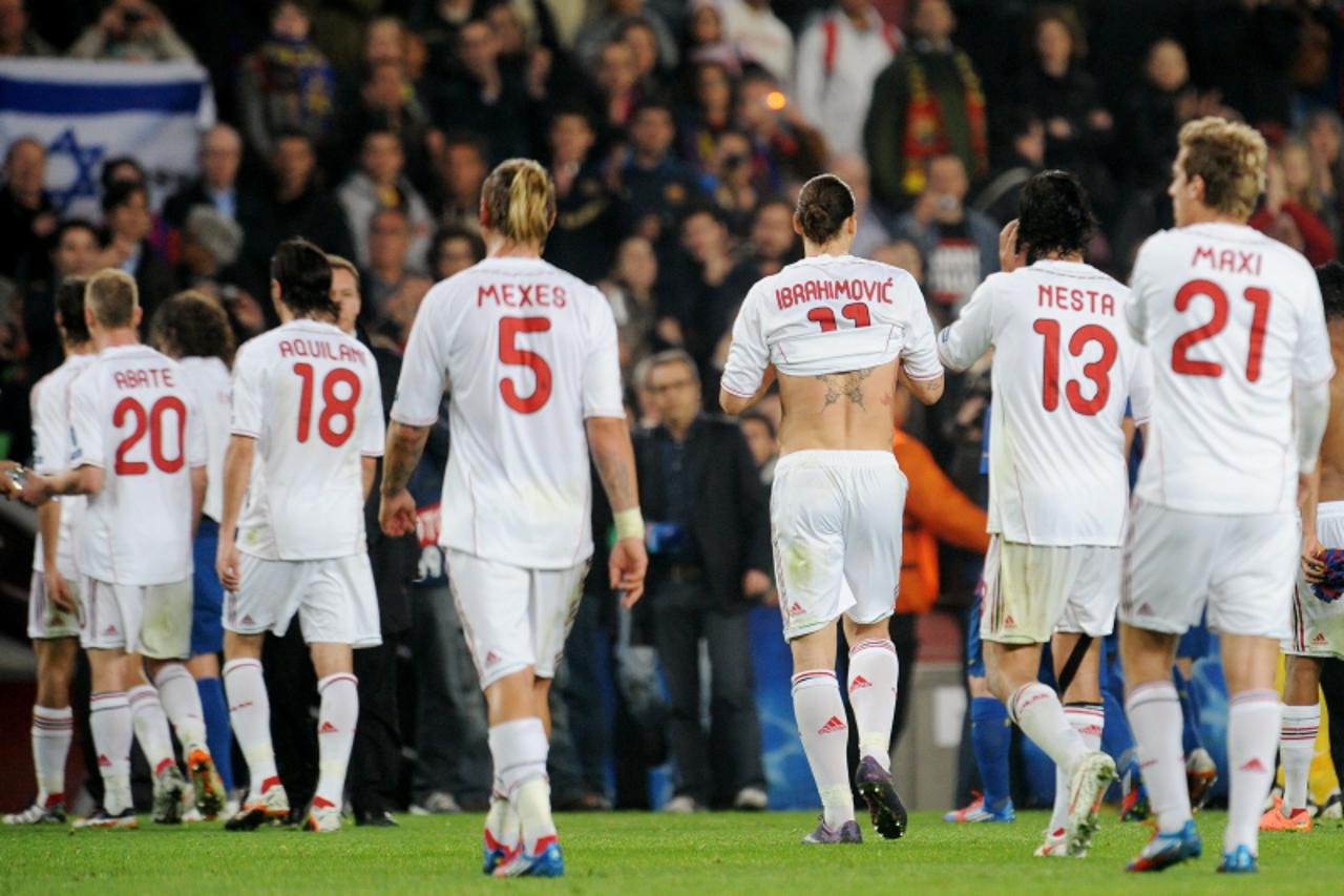 'AC Milan\'s players leave the pitch at the end of the Champions League quarter-final second leg football match FC Barcelona vs AC Milan on April 3, 2012 at Camp Nou stadium in Barcelona. FC Barcelona