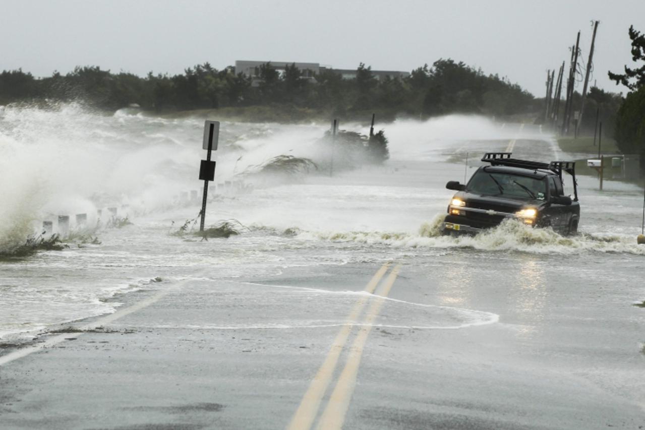 'A truck drives through water pushed over a road by Hurricane Sandy in Southampton, New York, October 29, 2012. Hurricane Sandy, the monster storm bearing down on the East Coast, strengthened on Monda