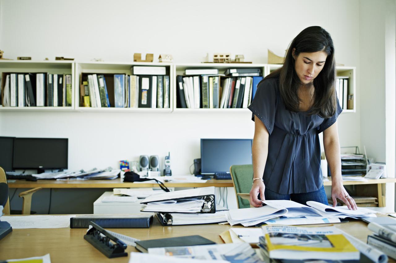 Female architect examining documents at desk